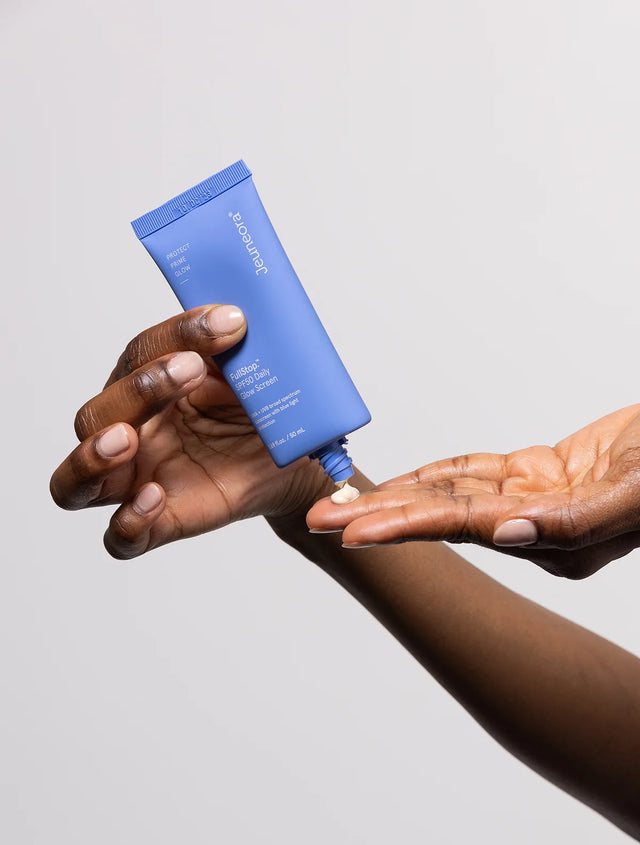 hand squeezing out sunscreen from blue tube