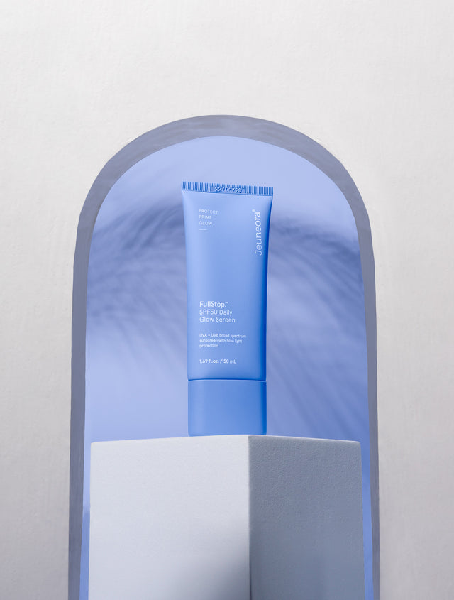 FullStop.™ SPF50 Daily Glow Screen on plinth with blue background