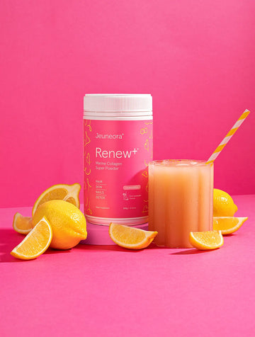 Pink Renew+™ Marine Collagen Super Powder set up with lemons on pink background